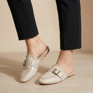 Mules plates style mocassin avec boucle décorative et détails perforés